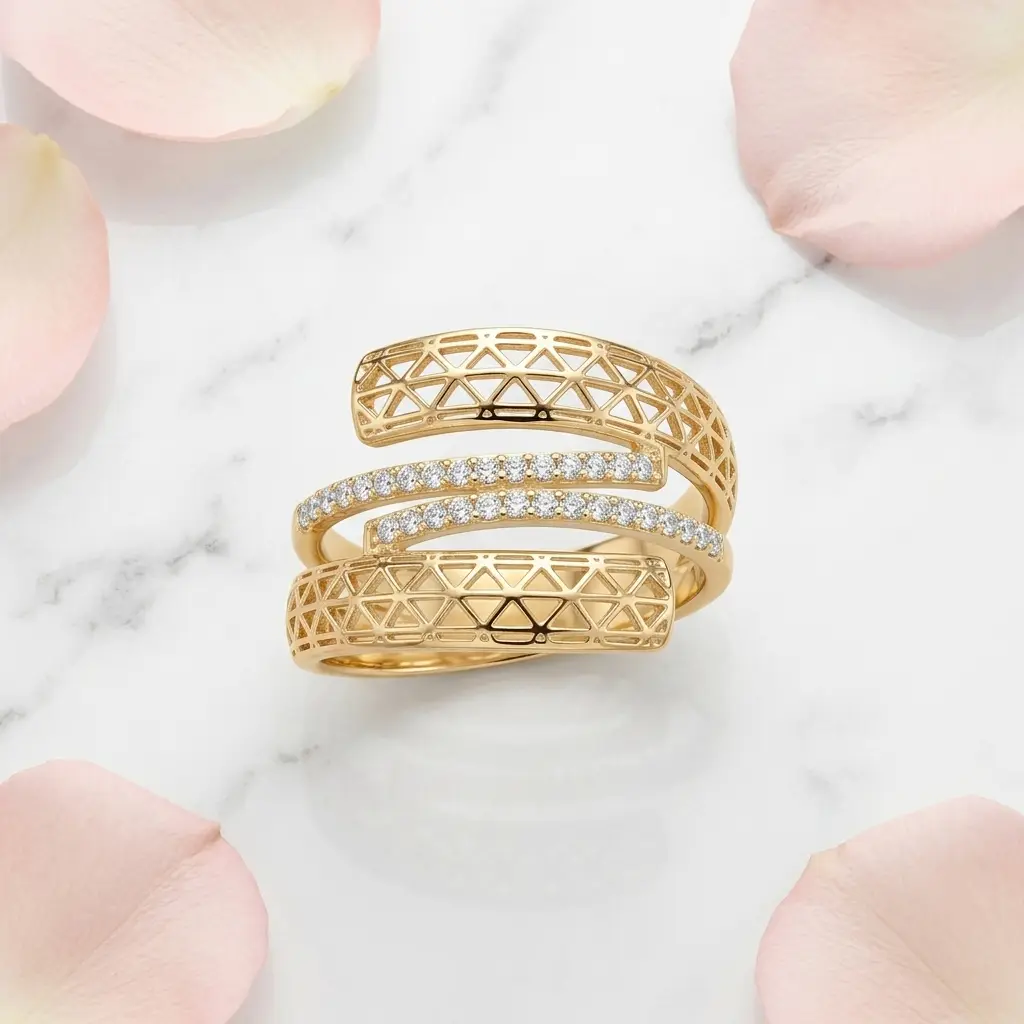 Anel espiral dourado sobre mármore branco com pétalas de rosa